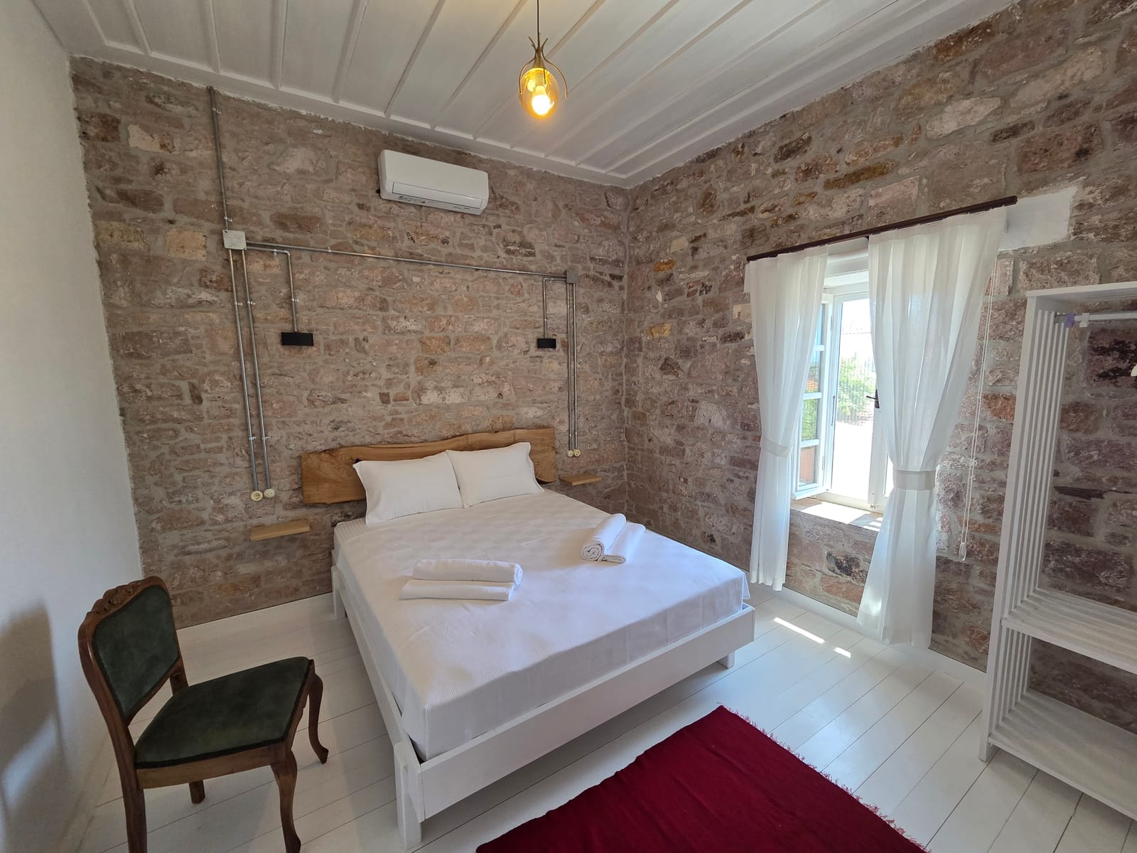 Numara 1 — taş duvarlı yatak odası, çift kişilik yatak ve beyaz ahşap tavan, Cunda Milos butik otel Ayvalık