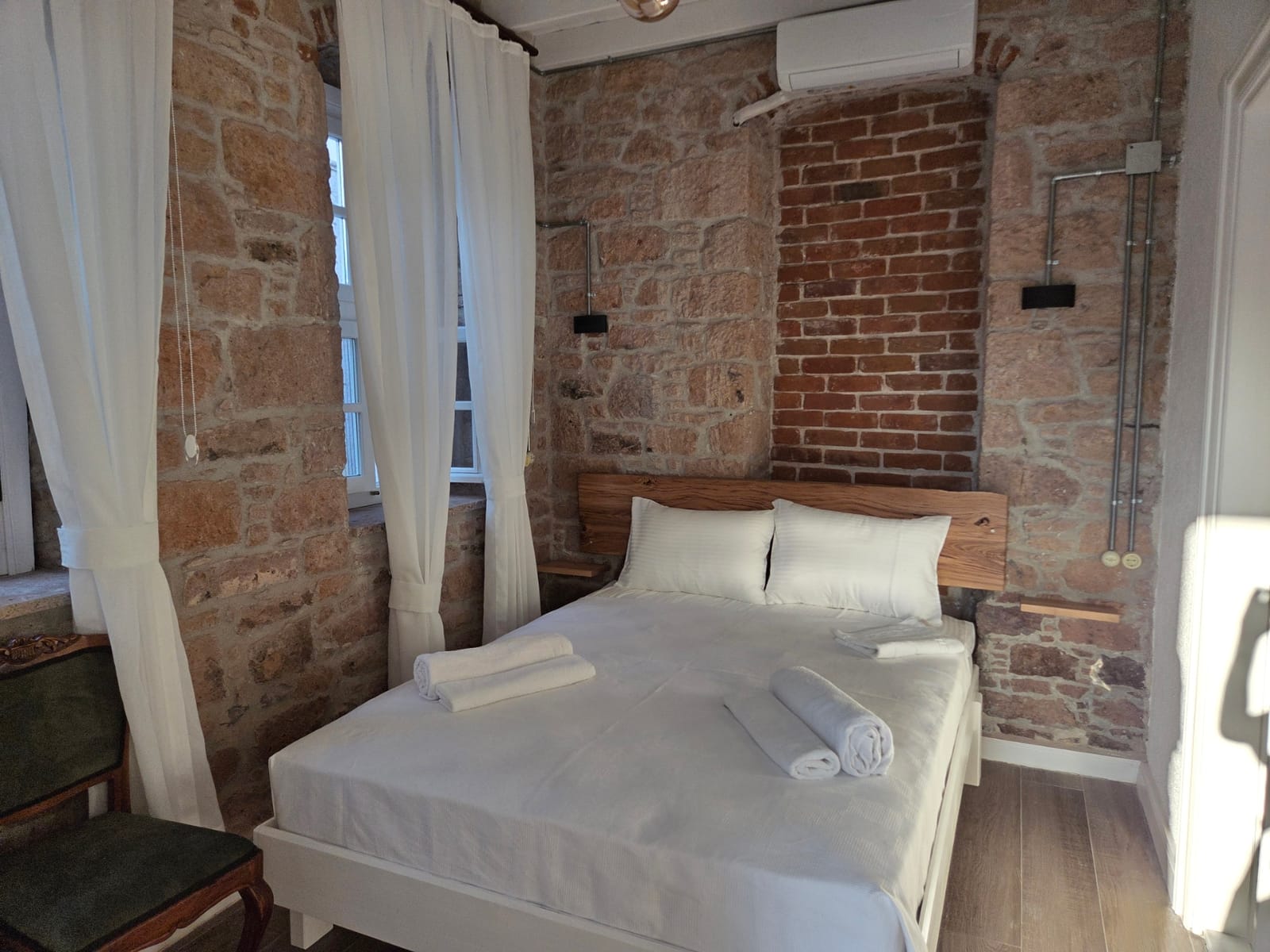 Numara 2 — taş ve tuğla duvarlar, ahşap başlıklı çift kişilik yatak, Cunda Milos butik otel Ayvalık